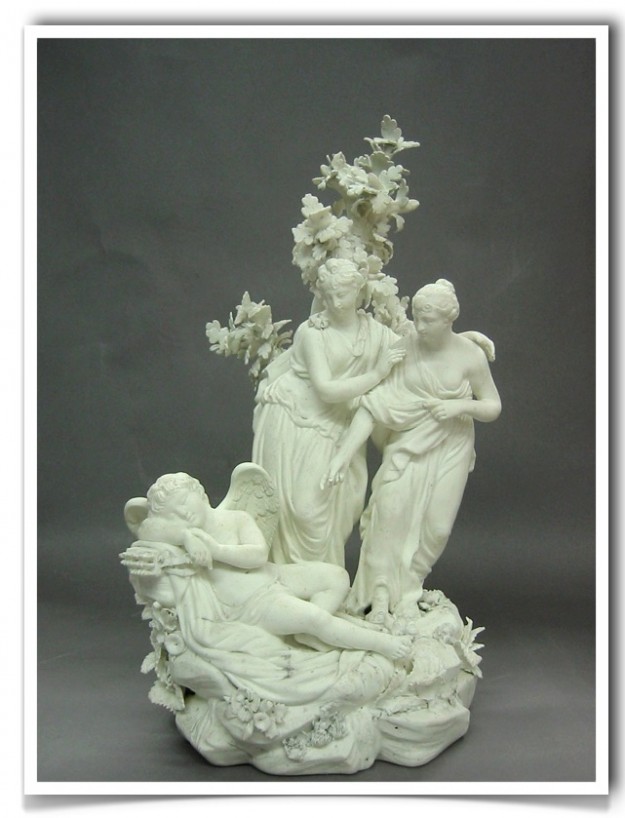 A white statue of two women and a man.