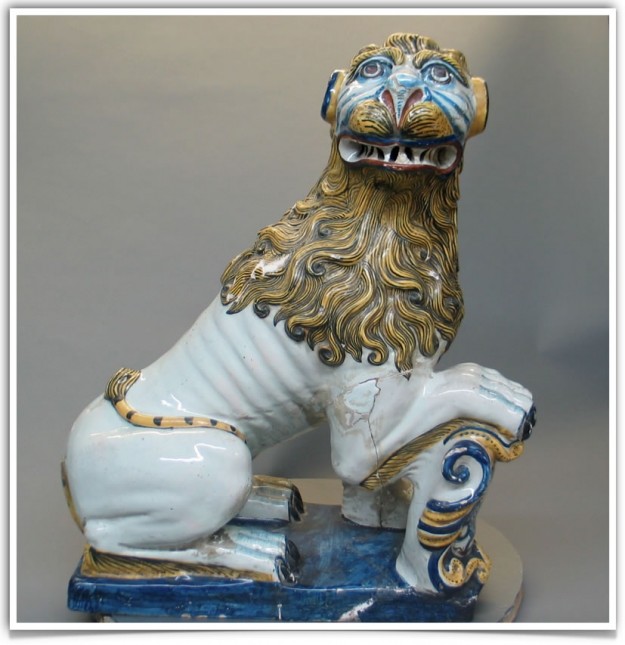 A ceramic lion statue sitting on top of a bench.