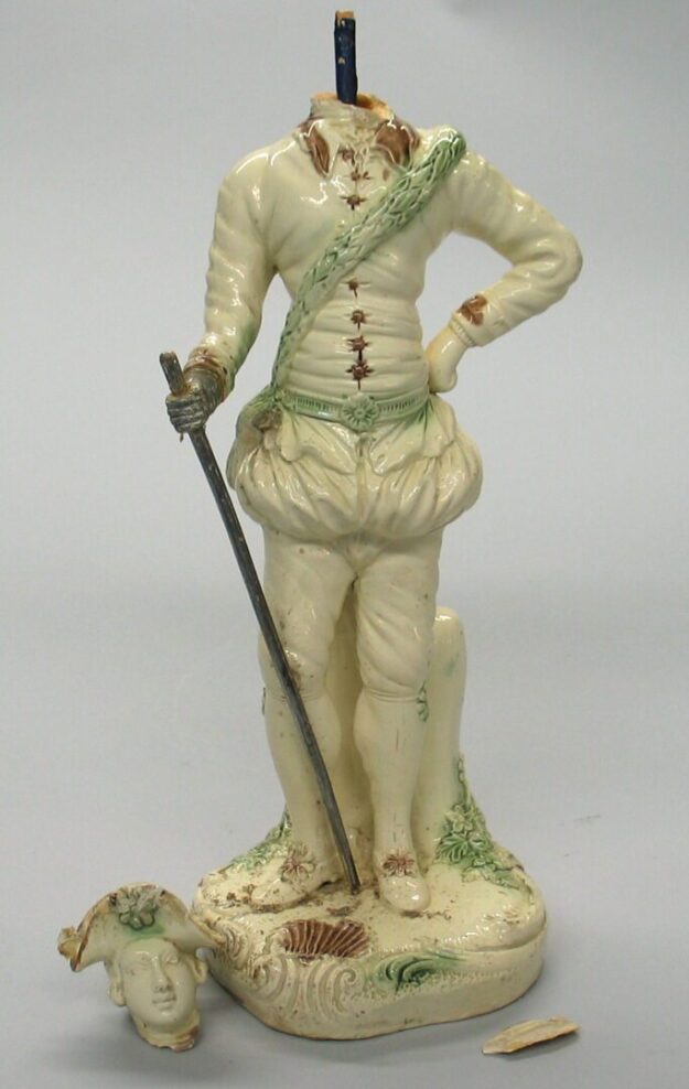 A statue of a man holding a sword and wearing a green sash.