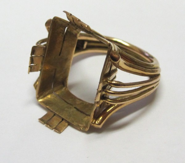 A gold ring with a square cut out of it.