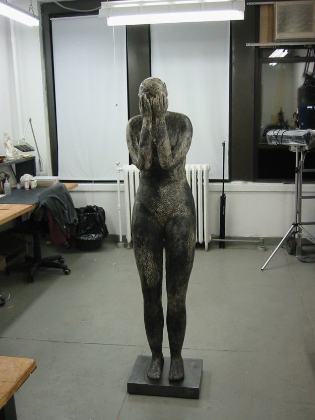 A statue of a woman in the middle of an art studio.