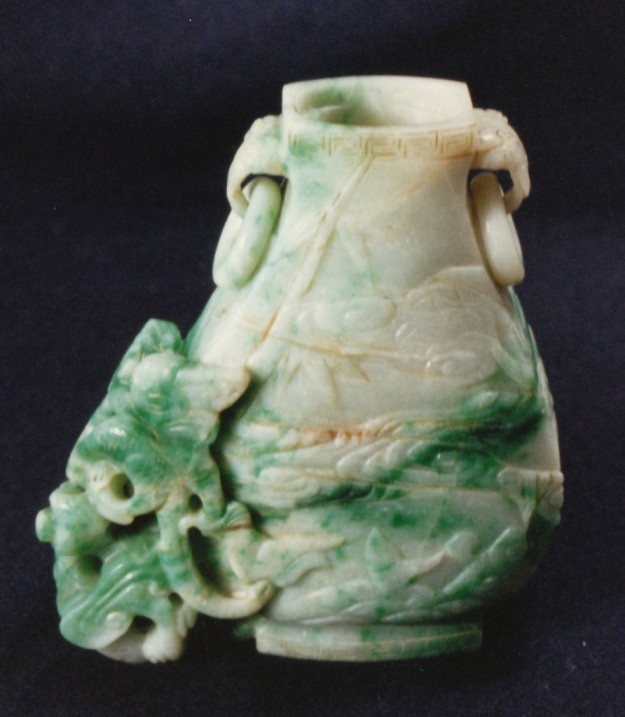 A green and white vase with a dragon design.