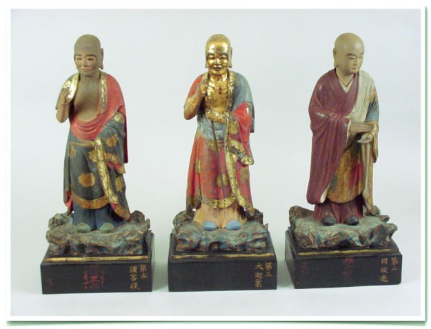 Three statues of a man and woman in different colors.