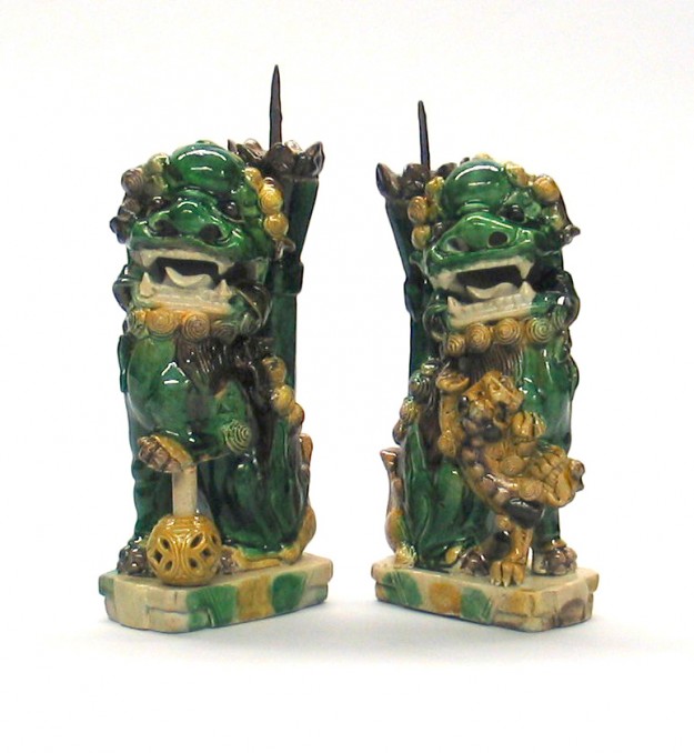 A pair of green and yellow statues with a sword.