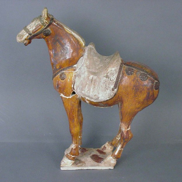 A horse statue with saddle on its back.