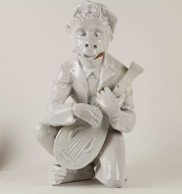 A white statue of a man holding a guitar.
