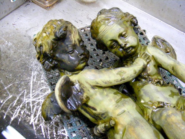 Two statues of children are laying on a tray.