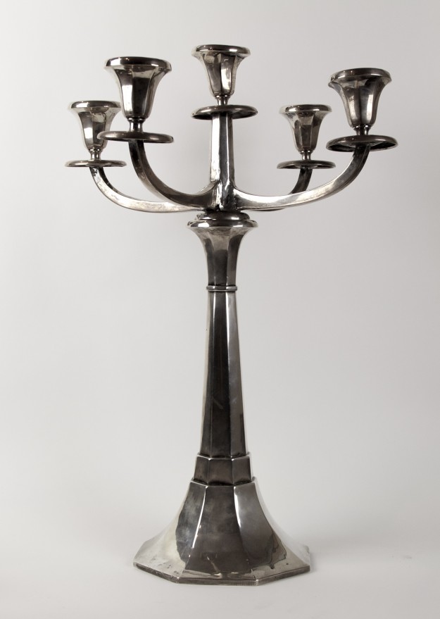 A silver candelabra is sitting on top of a table.