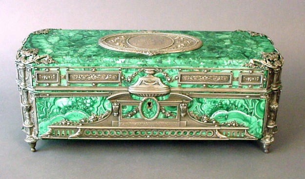A green box with silver trim and a medallion.