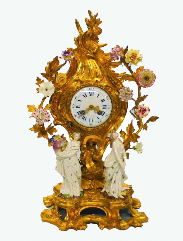 A gold clock with white and pink flowers on it.