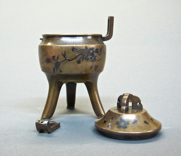 A small metal pot sitting on top of a table.