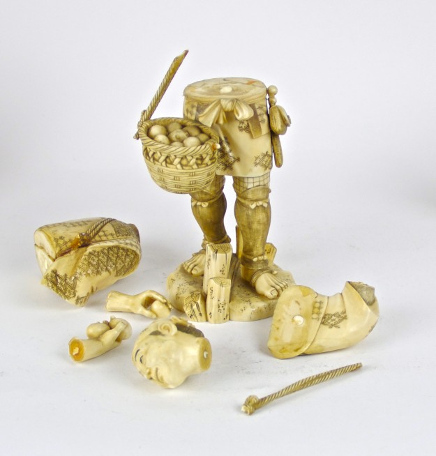 A sculpture of a person holding a basket and some other objects