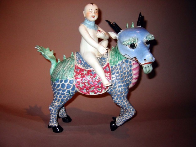 A ceramic figurine of a man riding on the back of a horse.