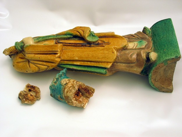 A wooden statue of a person with two pieces of wood.