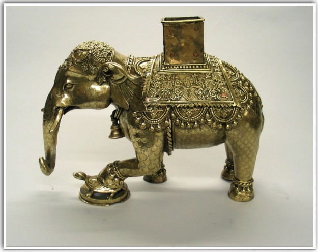 A gold elephant statue with a small pot on its back.