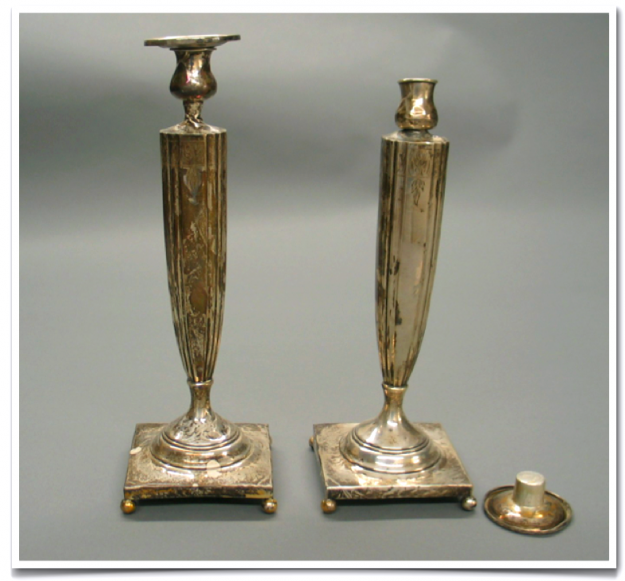 A pair of candlesticks with a candle holder.